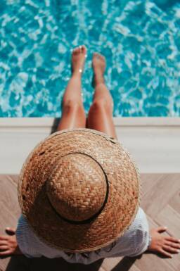 Christian woman in a hat by the pool